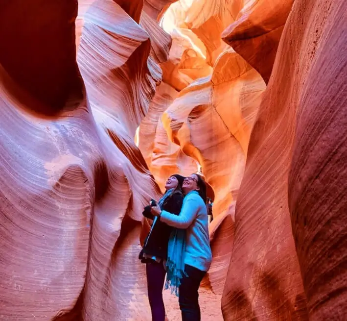 Two girls standing in the middle of a breathtaking Antelope canyon