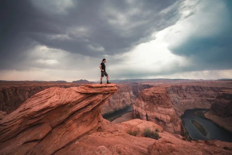 Man standing on top of horseshoe bend at Arizona photo